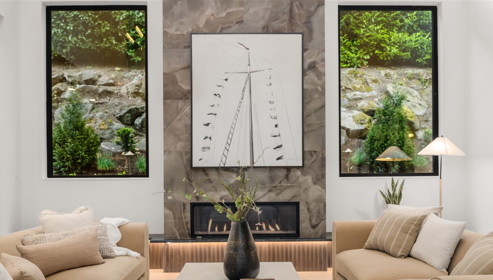 Living room with twin floor-to-ceiling windows flanking the fireplace